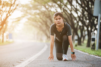 Portrait of young woman exercising on road