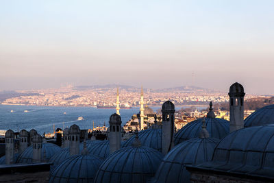 Mosque domes in city against sky