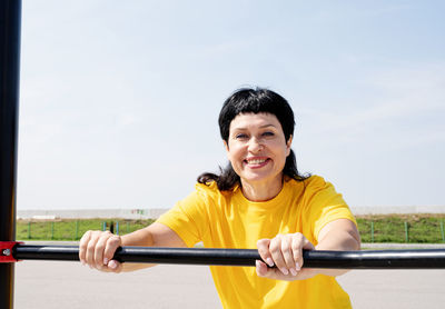 Portrait of a smiling young woman holding camera