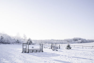 Snow covered field against clear sky