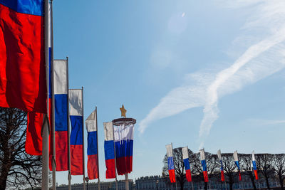 Low angle view of red flag against blue sky