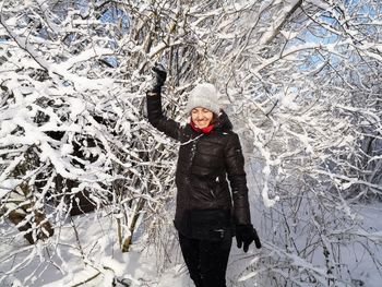 Portrait of a smiling woman standing in snow