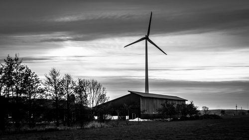 Windmill against cloudy sky