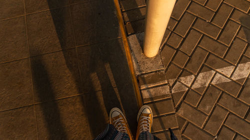 Low section of man standing on tiled floor