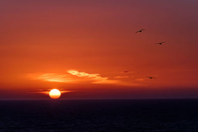 Scenic view of sea against romantic sky at sunset