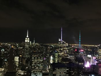 Illuminated city against sky at night