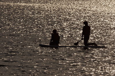 Silhouette people on sea shore