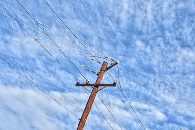 Low angle view of telephone pole against sky