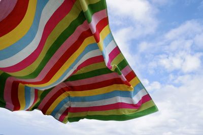 Low angle view of multi colored flag against sky