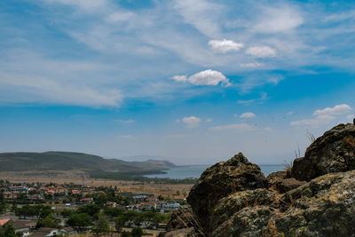 Aerial view of townscape by mountain against sky