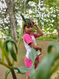 Cute girl smiling while standing against plants