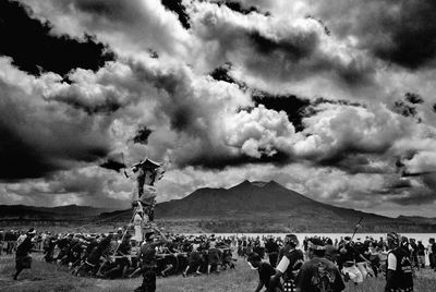 Group of people on land against the sky