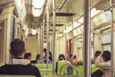 Rear view of man sitting in train