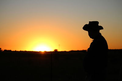 Silhouette man standing against sky during sunset