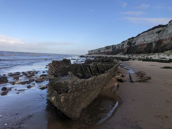 Rocks on beach against sky