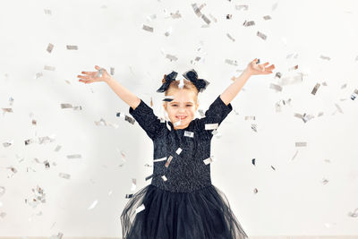 Portrait of smiling girl standing against wall