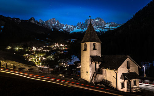 Illuminated buildings against sky at night in the mountains