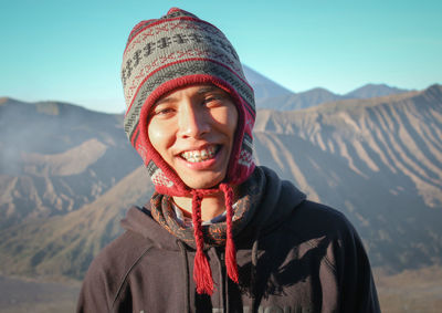 Portrait of smiling man in hat against mountains