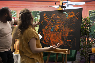 Rear view of woman sitting on table