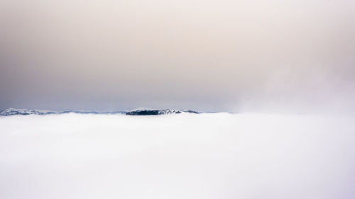 Snow covered landscape against sky