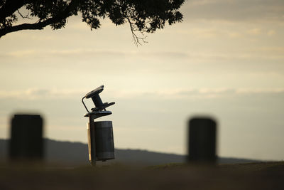 Close-up of silhouette metal on field against sky