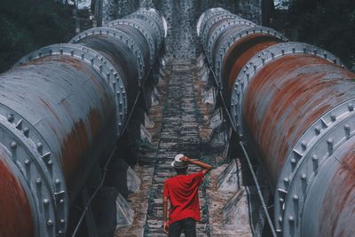 Rear view of man standing pipeline