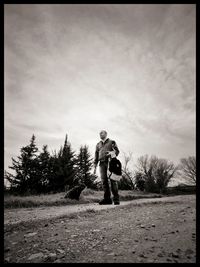 Man standing on field against sky