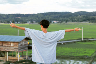 Rear view of man standing on field