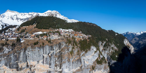 Panoramic view of snowcapped mountains against clear blue sky