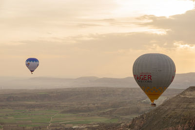 Hot air balloon flying over landscape against sky