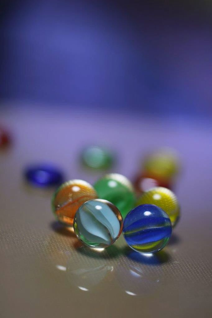 indoors, selective focus, still life, close-up, table, multi colored, focus on foreground, no people, glass - material, reflection, colorful, fragility, variation, transparent, blue, large group of objects, water, jewelry, high angle view, in a row