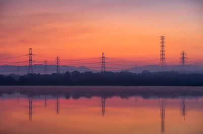 Electricity pylon or high-voltage transmission towers on the hill with reflection. 