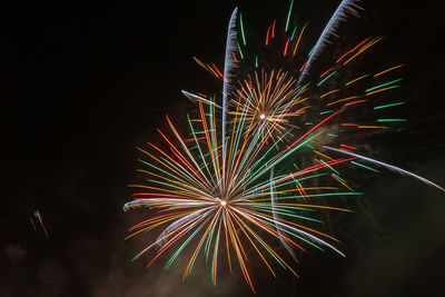 Low angle view of firework display at night