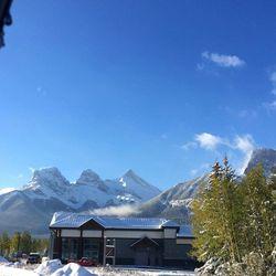 Houses by snowcapped mountains against sky