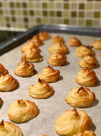 Close-up view of homemade duchess potatoes on a baking sheet with parchment paper