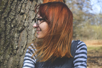 Close-up of woman sitting by tree