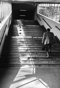 Rear view of people walking on staircase