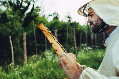 Close-up of man holding umbrella on land