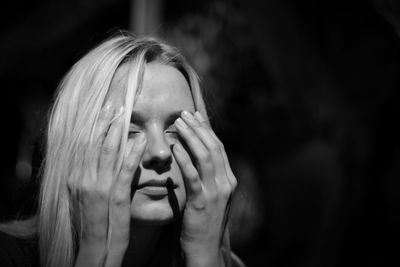 Close-up of woman with eyes closed in darkroom