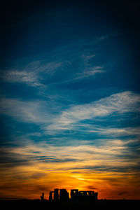 Silhouette buildings against sky at sunset