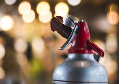 Close-up of bottle against illuminated lights