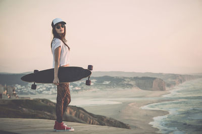 Beautiful young girl with her skateboard