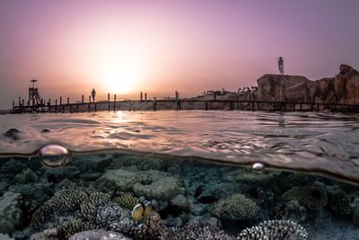 Surface level of beach against sky during sunset