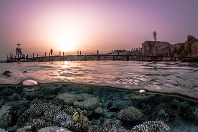 Surface level of sea against sky during sunset