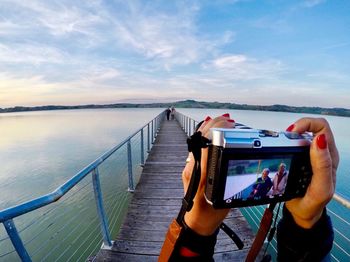 Rear view of woman photographing on beach