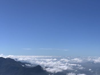 Scenic view of mountains against blue sky