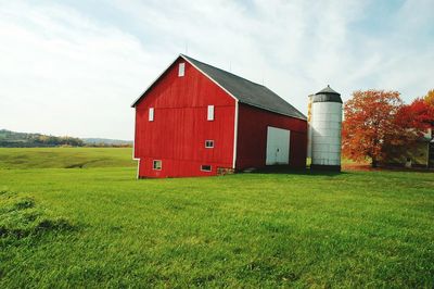 Built structure on grassy field against cloudy sky