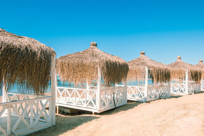 Massage huts with thatched roof on sand beach along seaside. luxury vacation resort spa