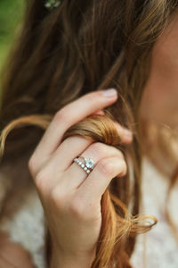 Close-up of woman wearing finger rings holding her hair