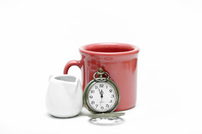 Close-up of clock on table against white background